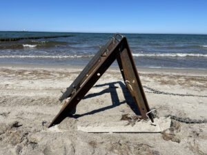 Metallkonstruktion am Ostseestrand vor Wellen im Meer