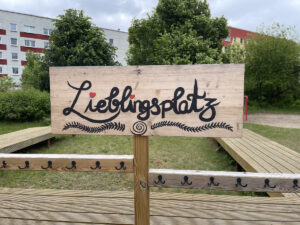 Holzschild im Garten der Kita mit der Aufschrift "Lieblingsplatz"