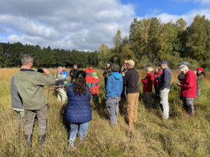 Menschen stehen als Gruppe auf dem Moorboden