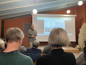 Person vor eine Leinwand im gefüllten Saal