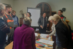 Menschen versammeln sich um Tische und einem Flipchart