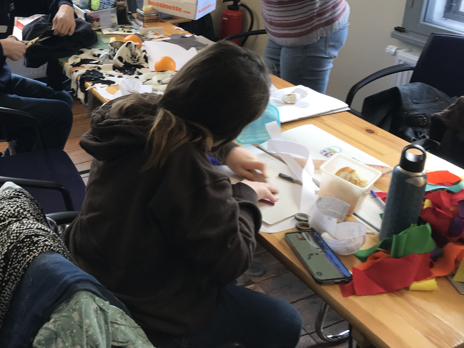 Jugendliche basteln am Tisch mit verschiedenen Materialien