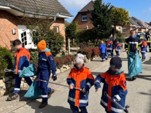 Kinder in Feuerwehruniformen laufen durch die Straße