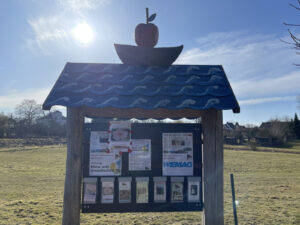 Holzgeschnitzte Informationstafel am Wegesrand