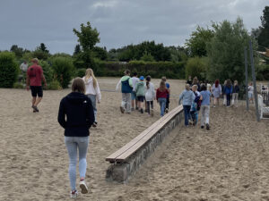 Jugendliche laufen am Strand des Bades zur anderen Seite