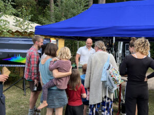 Gruppe von Eltern mit ihren Kindern versammelt um ein Aquarium mit Gewässerproben